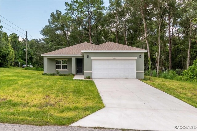 ranch-style home featuring a front lawn, stucco siding, a shingled roof, an attached garage, and driveway
