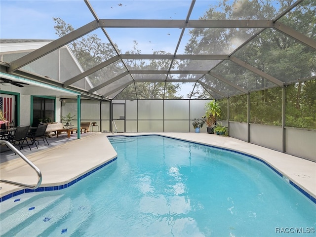 view of swimming pool featuring glass enclosure and a patio