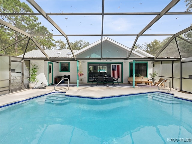 view of swimming pool featuring glass enclosure and a patio