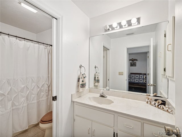 bathroom featuring tile patterned floors, vanity, and toilet