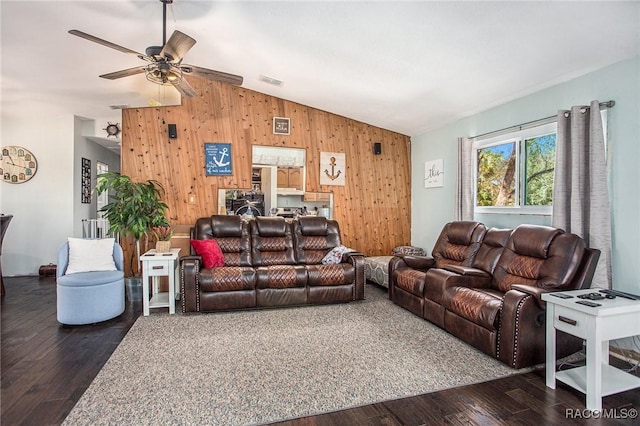 living room with lofted ceiling, wooden walls, dark hardwood / wood-style floors, and ceiling fan