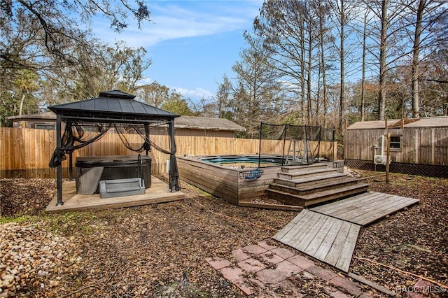 view of yard featuring a storage shed, a gazebo, and a hot tub