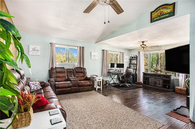 living room with ceiling fan, dark wood-type flooring, a textured ceiling, and vaulted ceiling