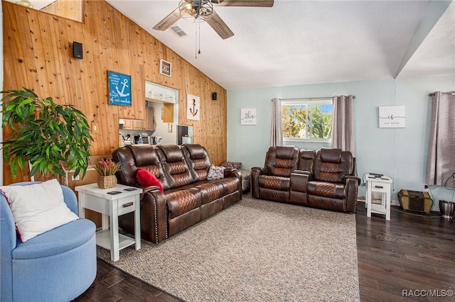 living room with ceiling fan, lofted ceiling, dark wood-type flooring, and wooden walls