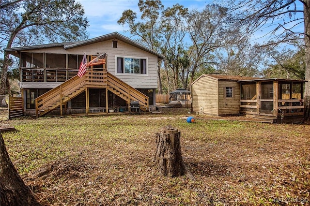 back of property featuring a sunroom and a lawn