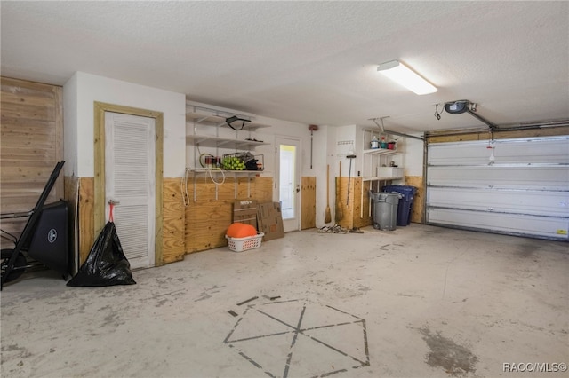garage with wooden walls and a garage door opener