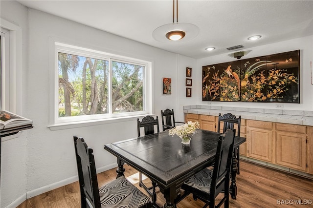 dining space with visible vents, baseboards, and light wood-type flooring