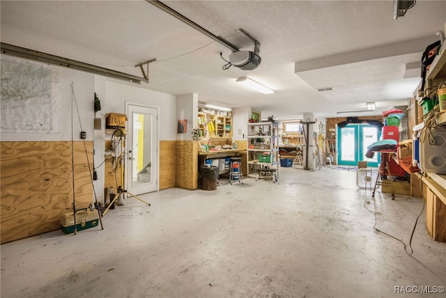 garage with a garage door opener and a workshop area