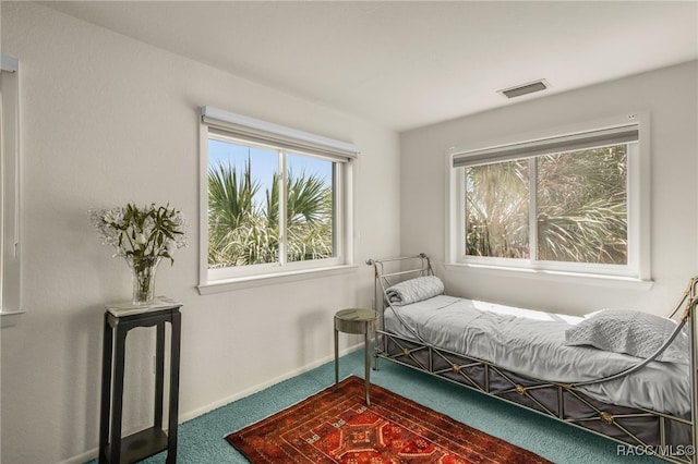 bedroom with visible vents, carpet flooring, baseboards, and multiple windows
