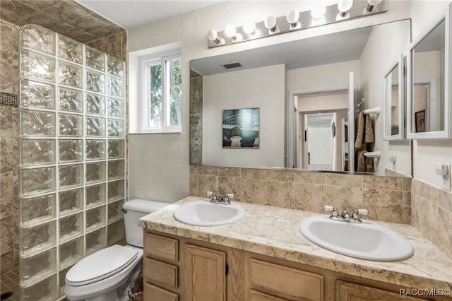 bathroom with visible vents, a sink, a walk in shower, and toilet