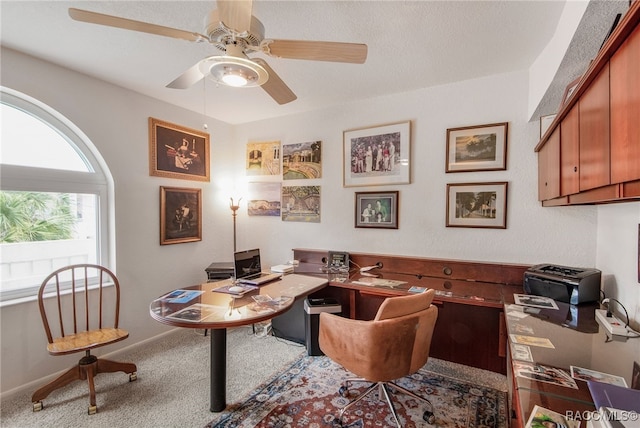 home office with carpet floors, ceiling fan, and baseboards