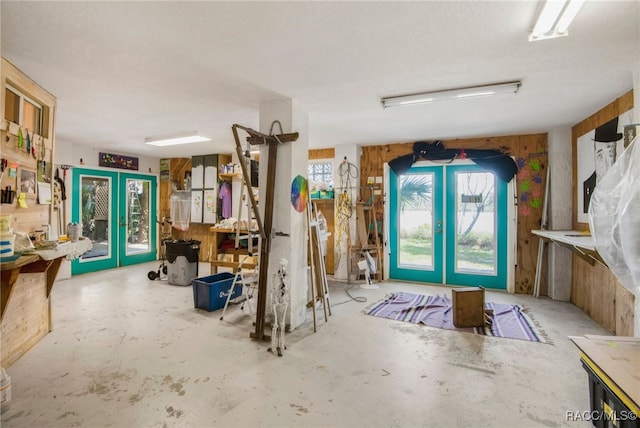 miscellaneous room with french doors and concrete floors