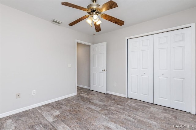 unfurnished bedroom with visible vents, baseboards, light wood-style flooring, ceiling fan, and a closet