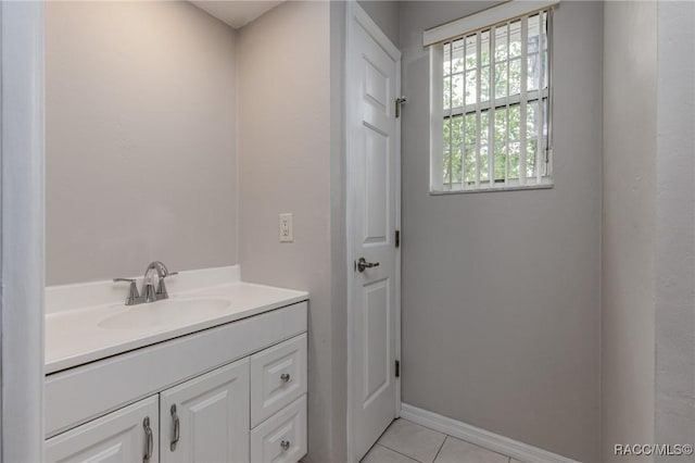 bathroom with vanity, baseboards, and tile patterned floors