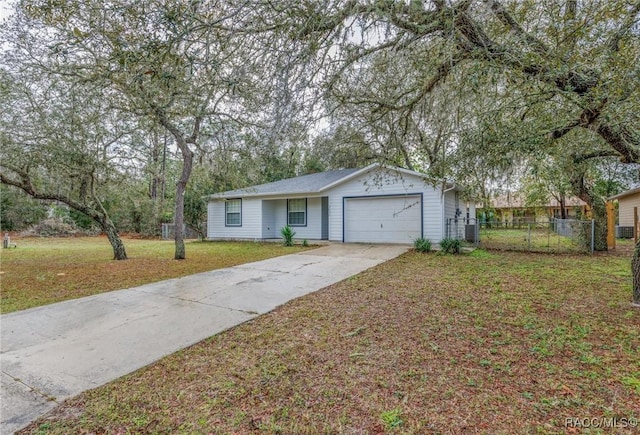 single story home with a garage, fence, concrete driveway, and a front yard