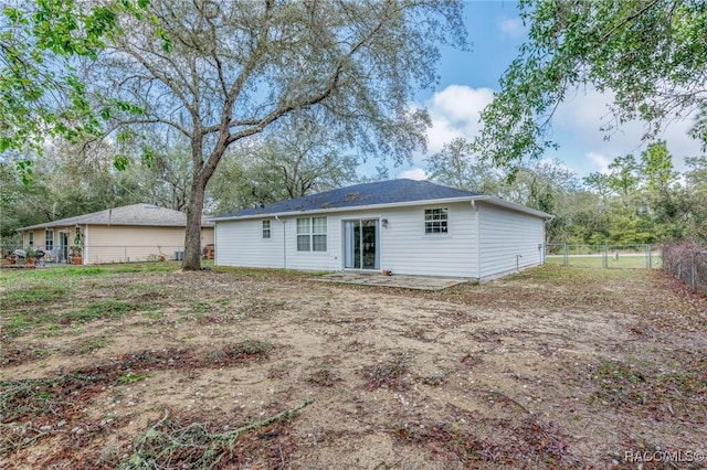 rear view of house featuring fence