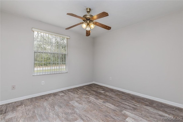 spare room with light wood finished floors, ceiling fan, and baseboards