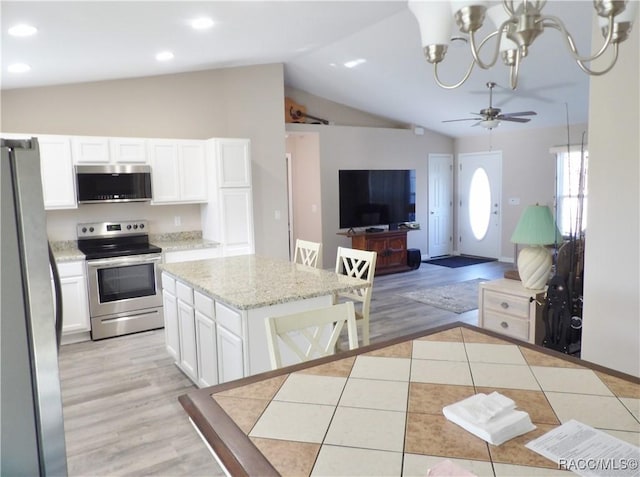 kitchen with white cabinetry, light tile patterned floors, stainless steel appliances, and a kitchen island