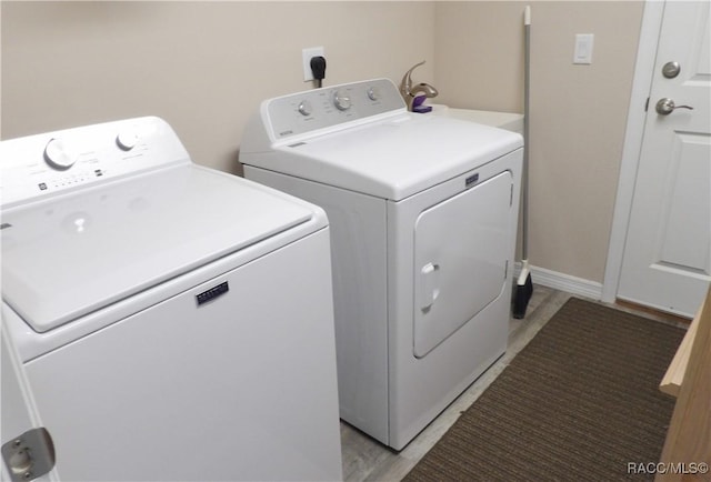 laundry room featuring washing machine and dryer and light wood-type flooring