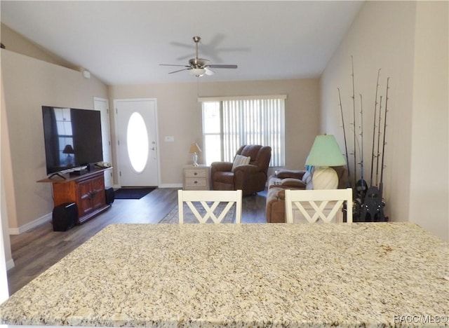 dining area featuring dark wood-type flooring, ceiling fan, and vaulted ceiling