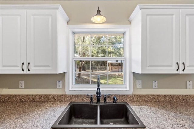 kitchen featuring white cabinetry and sink