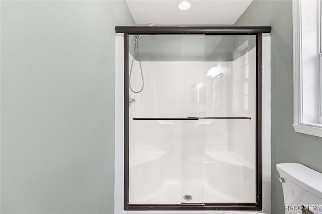 bathroom with an enclosed shower and toilet