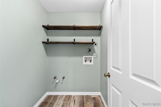 clothes washing area featuring electric dryer hookup, hookup for a washing machine, wood-type flooring, a textured ceiling, and hookup for a gas dryer