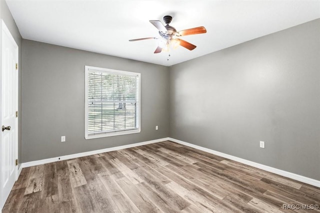 spare room with hardwood / wood-style floors and ceiling fan