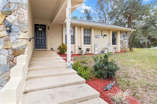 entrance to property featuring a lawn