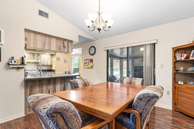 dining area featuring dark wood-type flooring, sink, lofted ceiling, and an inviting chandelier