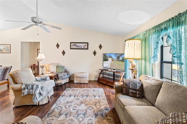 living room with lofted ceiling, ceiling fan, dark hardwood / wood-style flooring, and a textured ceiling