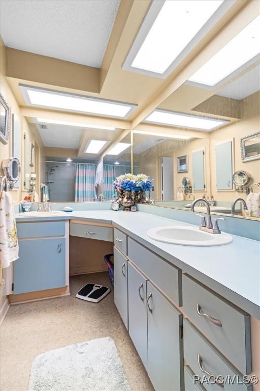 bathroom featuring a textured ceiling, vanity, and a shower with shower curtain