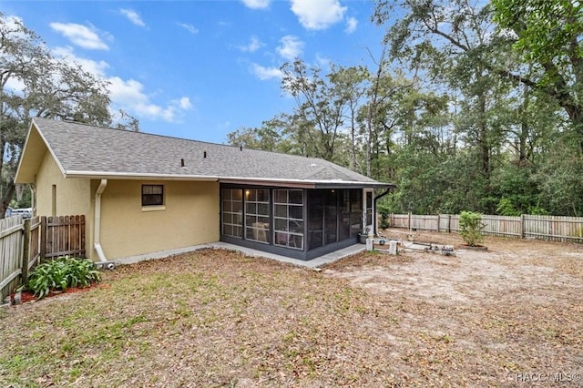 rear view of house featuring a sunroom