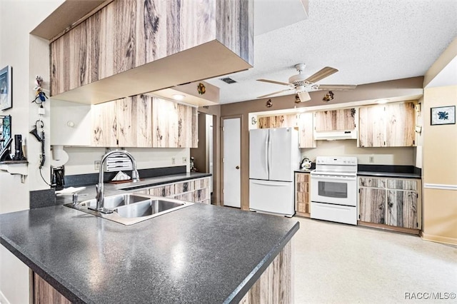 kitchen featuring kitchen peninsula, sink, white appliances, and a textured ceiling