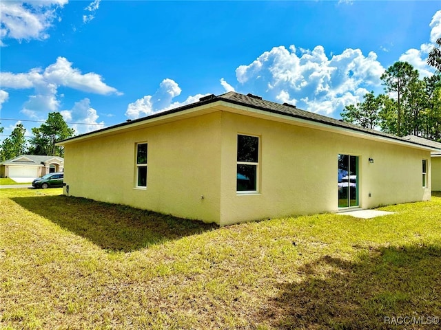 rear view of property featuring a lawn