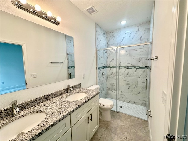 bathroom featuring vanity, tile patterned floors, toilet, a textured ceiling, and a shower with shower door