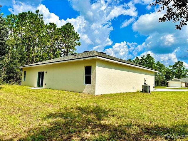 view of side of home with a yard and central AC unit