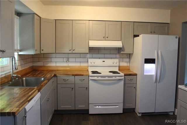 kitchen with white appliances, sink, dark hardwood / wood-style floors, decorative backsplash, and butcher block counters