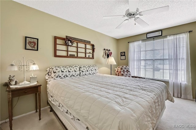 bedroom with light carpet, a textured ceiling, a ceiling fan, and baseboards