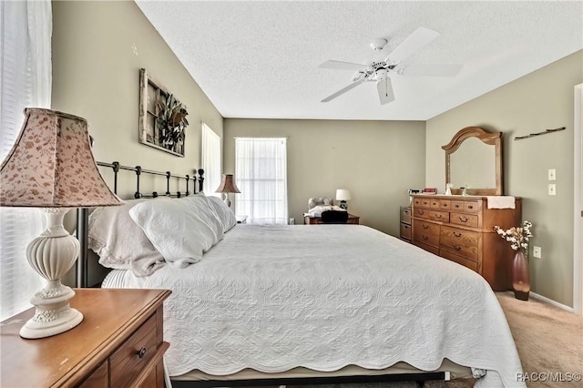 carpeted bedroom featuring baseboards, a ceiling fan, and a textured ceiling