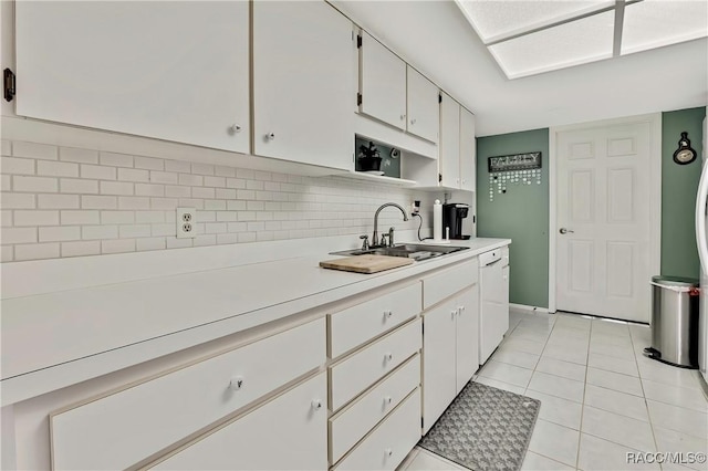 kitchen featuring a sink, white cabinetry, light countertops, decorative backsplash, and dishwasher