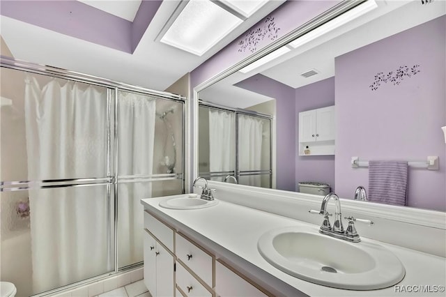 bathroom featuring visible vents, a sink, toilet, and double vanity