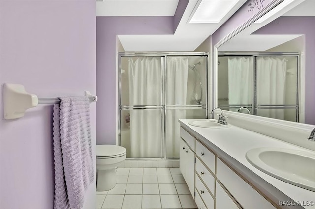 full bathroom featuring double vanity, a sink, toilet, and tile patterned floors