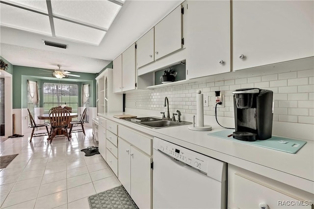 kitchen with a sink, white cabinets, light countertops, dishwasher, and open shelves