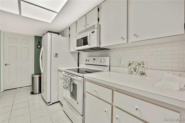 kitchen featuring light tile patterned floors, light countertops, backsplash, white cabinets, and white appliances