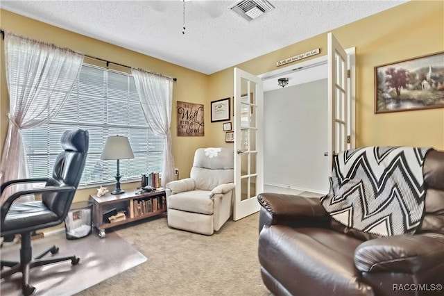 office space featuring light carpet, visible vents, a textured ceiling, and french doors