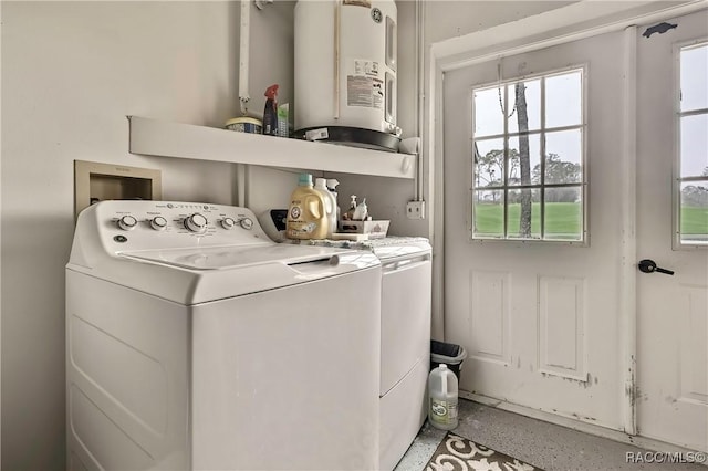 washroom with washer and dryer, laundry area, and water heater