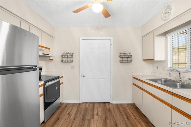 kitchen featuring white cabinets, sink, stainless steel appliances, and extractor fan