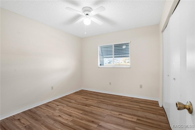 spare room with a textured ceiling, hardwood / wood-style flooring, and ceiling fan