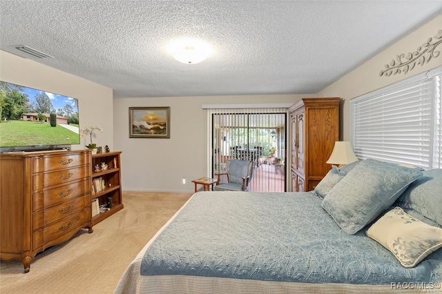 bedroom with access to outside, light carpet, and a textured ceiling